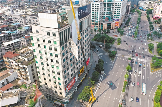 由于要拆除的廣告牌在樓頂，工作人員動用75米高的吊機進行作業(yè)。