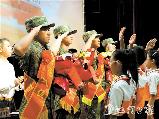 小學(xué)生代表向入伍新兵代表獻上鮮花。