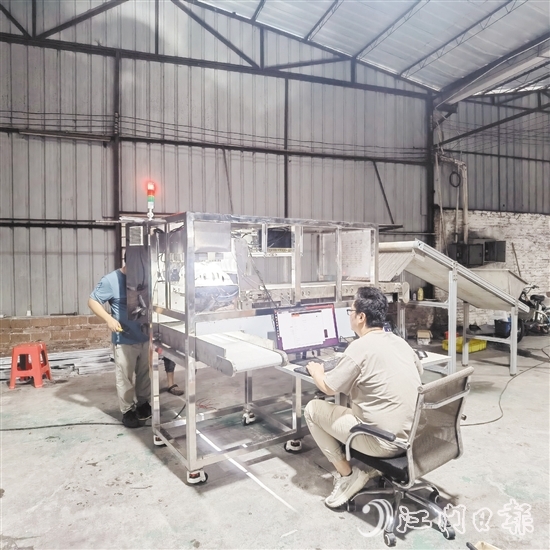 鷹視光電工作人員正在對AI視覺檢測設(shè)備進行調(diào)試。