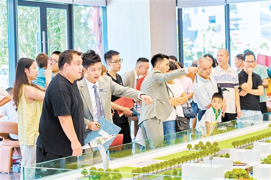 在駿景灣·品悅，銷售人員忙著為客戶介紹樓盤情況。