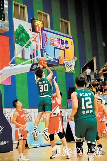萬村籃球賽江門市級賽決賽現(xiàn)場，橫江村隊隊員迎著防守跳投得分。