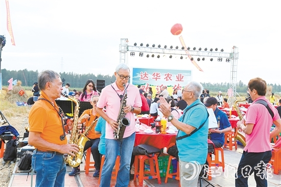 表演人員在稻田里吹響薩克斯風(fēng)，與澳門禮樂鄉(xiāng)親齊慶豐收。