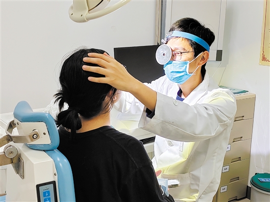 醫(yī)生為患者檢查鼻子。