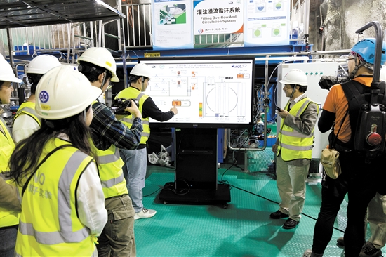 12月18日，江門中微子實驗項目經理王貽芳院士（右二）和科研人員一起啟動液體灌注。