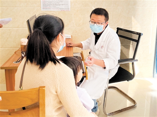 醫(yī)生正在接診呼吸道疾病患兒。