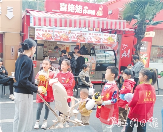 統(tǒng)一身著志愿者服裝的孩子們化身“愛心小掌柜”，向顧客推銷商品。