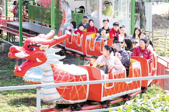 在位于江海區(qū)的江門長廊生態(tài)園，市民游客坐上小火車，享受闔家歡樂時(shí)光。