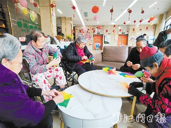 老人們圍坐在桌前，專注地制作小風車。