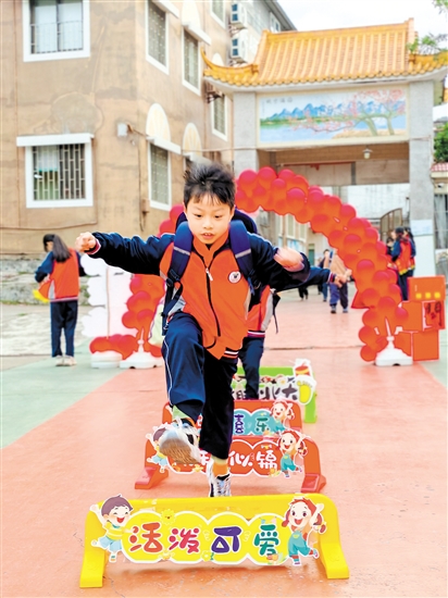 蓬江區(qū)荷塘鎮(zhèn)聯(lián)育小學(xué)學(xué)生跨過(guò)吉祥欄。