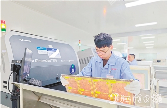 在鶴山中富生產(chǎn)車間，員工操作自動(dòng)化設(shè)備趕制電路板。