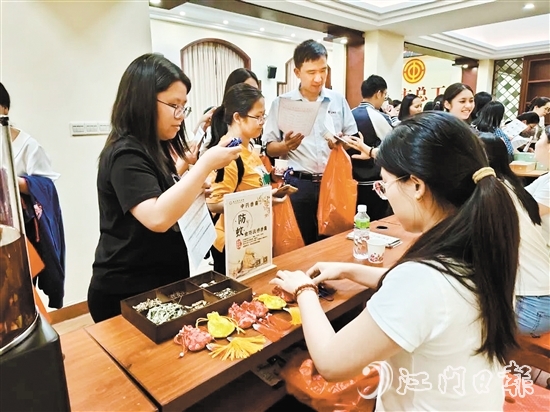 職工們與醫(yī)生探討中藥的成分和比例，制作防感驅(qū)蚊中藥香囊。