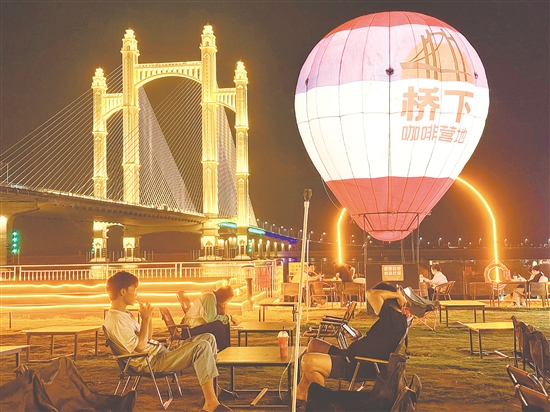 夜幕降臨，潭江兩岸燈火闌珊，市民、游客在“橋下咖啡營(yíng)地”品咖啡、賞夜景，享受愜意時(shí)光。