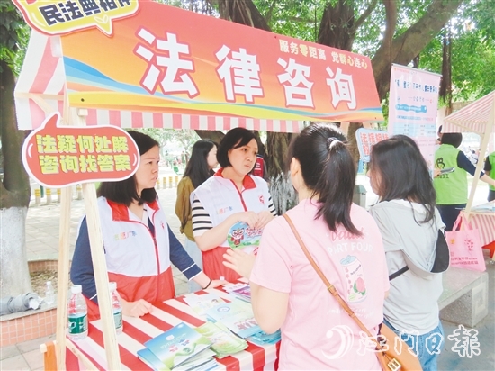 在法律援助攤位，司法系統(tǒng)黨員志愿者耐心解答群眾的法律咨詢。