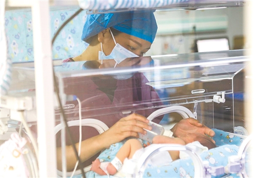這是一雙小心翼翼的手。在江門市婦幼保健院新生兒科，護士李麗婷化身臨時“奶媽”，手持奶瓶給早產(chǎn)兒喂奶。她時而調(diào)整奶瓶角度，時而放緩速度，用耐心與愛心為小生命構筑溫暖港灣，陪伴他們跨越成長路上最初的難關。