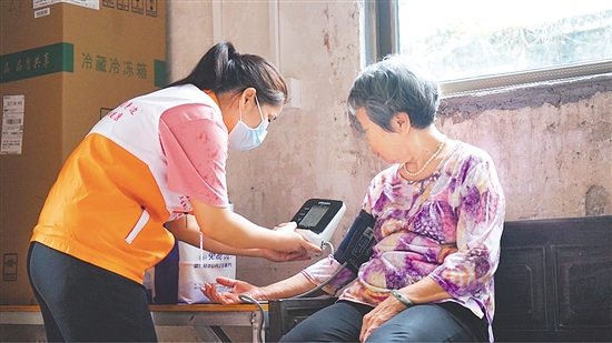 這是一雙不辭辛勞的手。江門市中心醫(yī)院蓬江分院環(huán)市街道社區(qū)衛(wèi)生服務中心護士劉娟冒雨上門，為基層群眾測量血壓、送藥，開展常規(guī)檢查和日常健康指導，將關懷與專業(yè)送進千家萬戶。