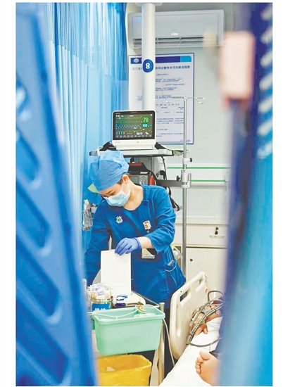 這是一雙爭分奪秒的手。急診搶救室是與時間賽跑的“生命戰(zhàn)場”，收治的都是急危重癥患者，生死往往就在一瞬間。面對心梗病人，江門市中心醫(yī)院急診科護士譚秀娟正專心致志地為患者做心電圖檢查，用專業(yè)與仁心守護生命之光。