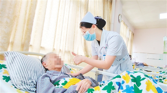 這是一雙傳遞溫度的手?！坝袝r去治愈，常常去幫助，總是去安慰”，江門市第三人民醫(yī)院內(nèi)科護士容海清站在床邊，將大拇指高高豎起，用輕柔的話語與溫暖的肢體語言，鼓勵臥床患者樹立康復的信心。