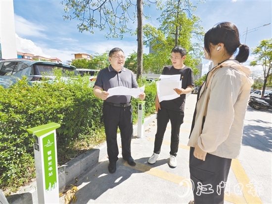 余中宏（左一）與同事一起查看“民生服務(wù)充電站”項(xiàng)目建設(shè)進(jìn)度。