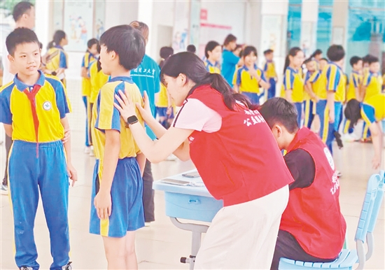 華南理工大學(xué)體育學(xué)院運(yùn)動(dòng)與健康科研團(tuán)隊(duì)為學(xué)生進(jìn)行專業(yè)的脊柱側(cè)彎篩查。