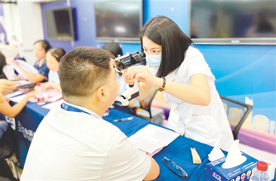 醫(yī)護(hù)人員為企業(yè)職工檢查眼睛。