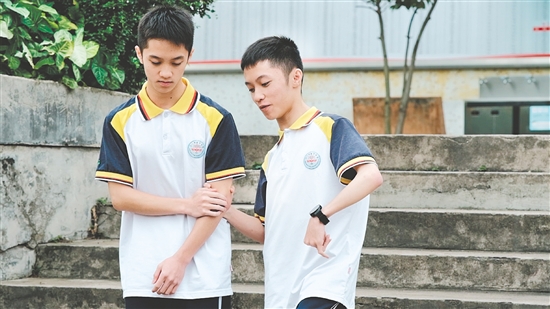 校園里，弟弟（左）和哥哥（右）相互扶持。