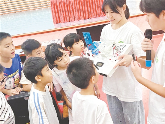 服務(wù)隊(duì)隊(duì)員向孩子們展示氫燃料電池演示儀。