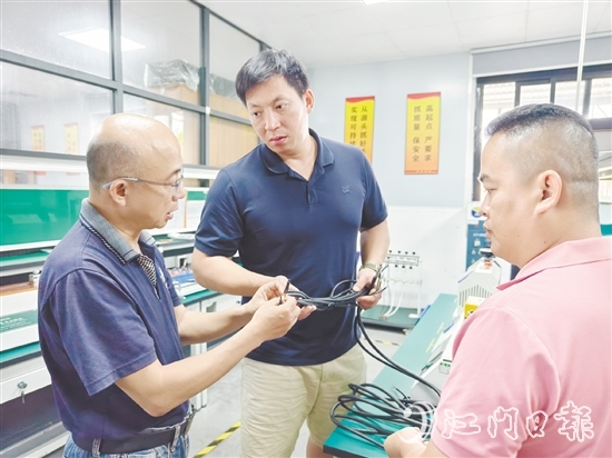 盧慶忠（中）與技術人員交流產(chǎn)品質量問題。