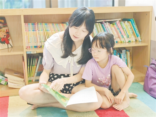 在龍溪湖閱讀中心，一位家長正陪伴孩子讀繪本。
