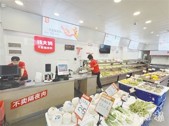 錢(qián)大媽生鮮店的工作人員正在線上接單并準(zhǔn)備菜品。