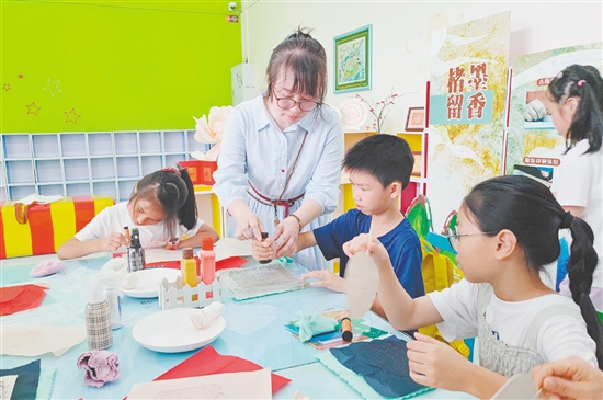 在導(dǎo)師的指導(dǎo)下，孩子們紛紛拿起紙張，在拓板上謹(jǐn)慎操作。