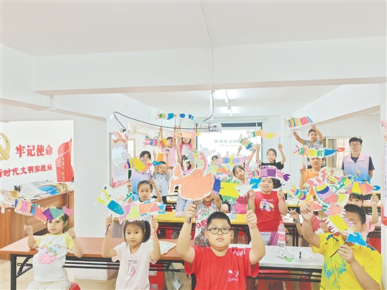 孩子們手持自制荷塘紗龍一起合照，課堂變民俗小舞臺。