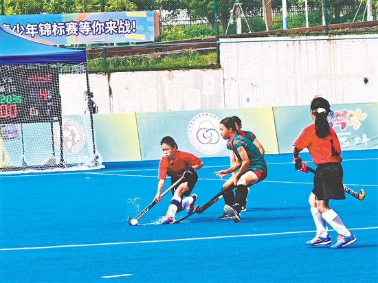 共和鎮(zhèn)中心小學(xué)女子曲棍球隊隊員（紅色隊服）在比賽中頑強拼搏。