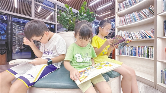 低年級學生圍坐在書架旁閱讀繪本。