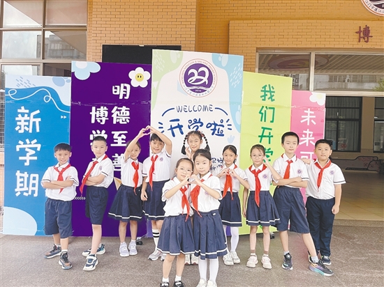 開學(xué)首日，農(nóng)林雙朗小學(xué)的學(xué)生們在學(xué)校精心準(zhǔn)備的背景板前留影。