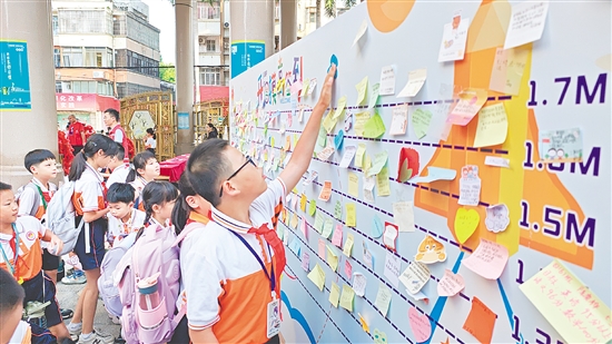 沙坪街道第一小學(xué)設(shè)立“開學(xué)摸高簽到墻”，學(xué)生貼上寫有新學(xué)期愿望的“心愿卡”。