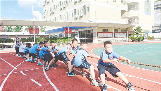 參賽隊(duì)員們緊握長(zhǎng)繩，齊心協(xié)力，鼓足勁拼命往后拉。