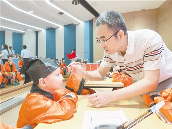 在朱砂啟智環(huán)節(jié)，教師用毛筆在新生的額頭點(diǎn)上紅痣。