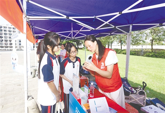 工作人員向新入學學生介紹醫(yī)保線上辦事流程。