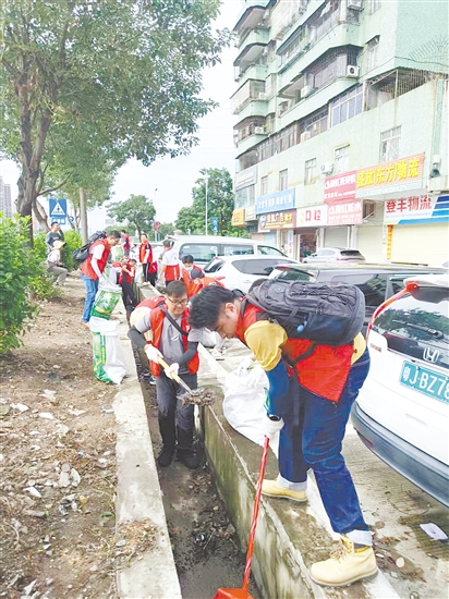 黨員防疫突擊隊隊員在開平市長沙街道南島社區(qū)清理垃圾。