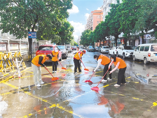 廣東江門(mén)中醫(yī)藥職業(yè)學(xué)院大學(xué)生志愿者合力清掃街道積水。