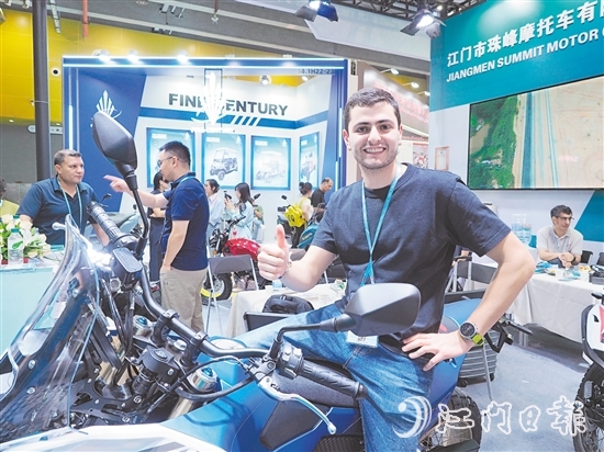 在江門市珠峰摩托車有限公司展位，外國客商前來了解摩托車新品情況，并為產品點贊。張澤彬