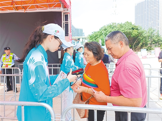 志愿者在場館外為觀眾檢票。
