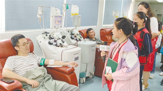 小記者采訪正在獻(xiàn)血的志愿者。