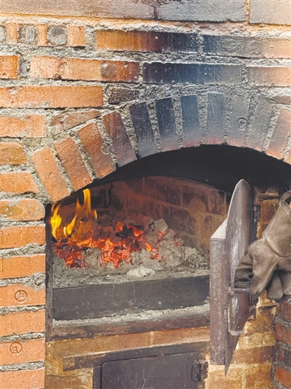 荔枝柴要燒兩個多小時，窯爐溫度到350℃以上才能烤面包。