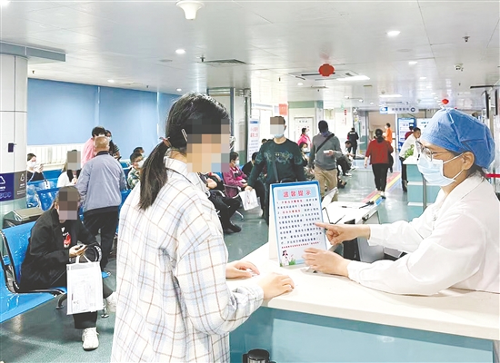 醫(yī)護(hù)人員向市民介紹“一次掛號管一次就醫(yī)流程”相關(guān)內(nèi)容。