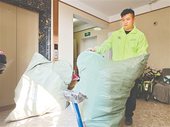 環(huán)保騎士工作人員為居民上門提供廢品回收服務(wù)。