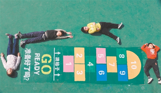 畫完“跳格子”后，學生們興奮地躺在地上合影。