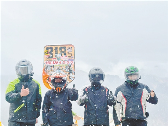 余鴻威（右一）與“旅游搭子”騎摩托車到西藏途中合影留念。