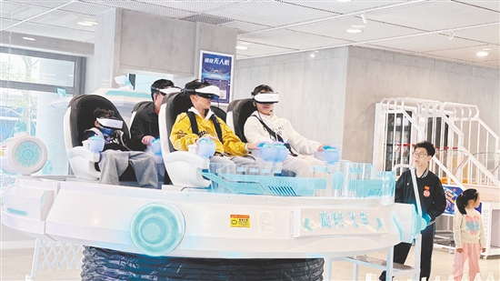 學(xué)生在科創(chuàng)中心體驗旋轉(zhuǎn)飛車。