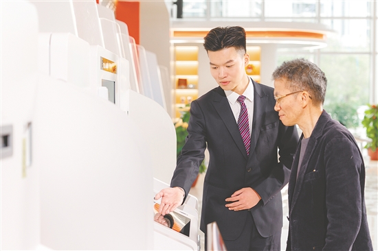 江門農(nóng)商銀行工作人員在為客戶講解社?？ǚ?wù)。